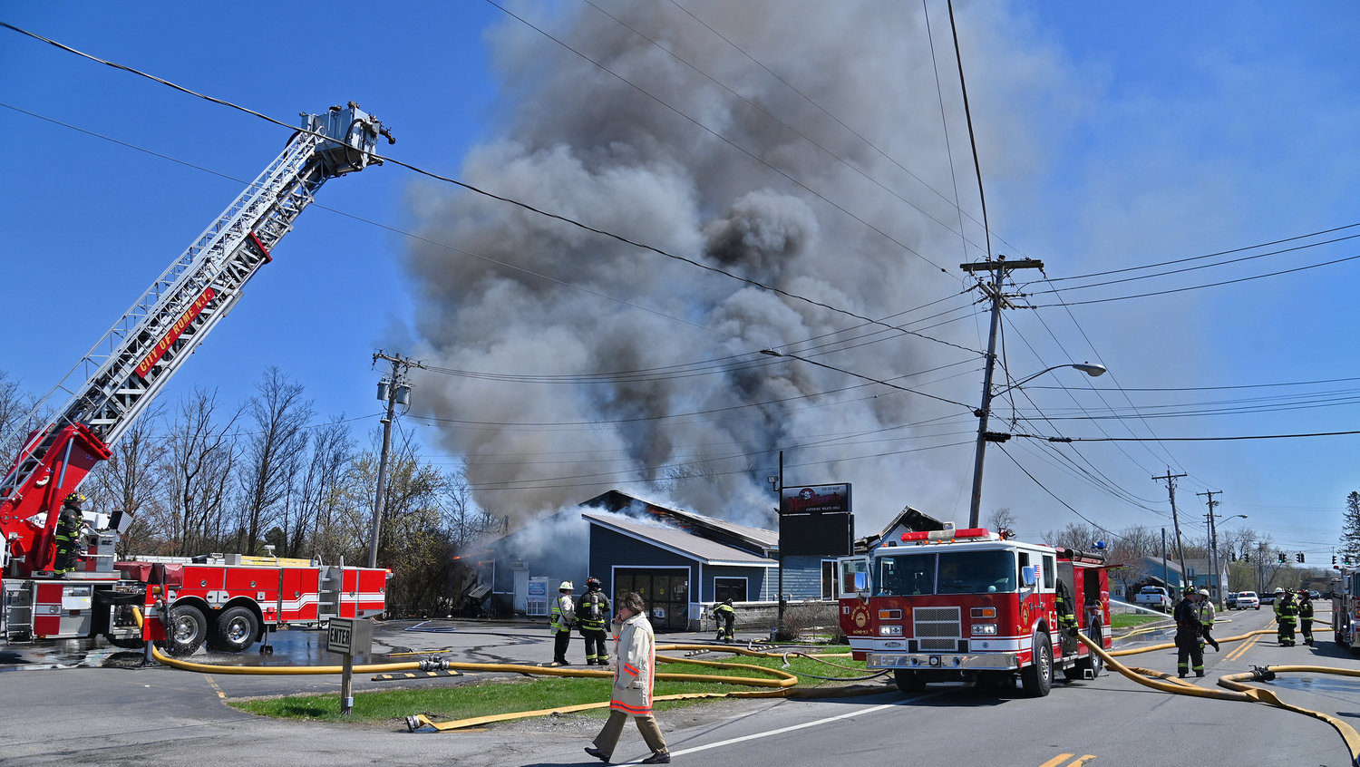 ATTACK FROM ALL SIDES — The Rome Fire Department's tower truck rises high above Mazzaferro's Meats & Deli in north Rome Friday afternoon, as city firefighters attack the blaze from all sides.