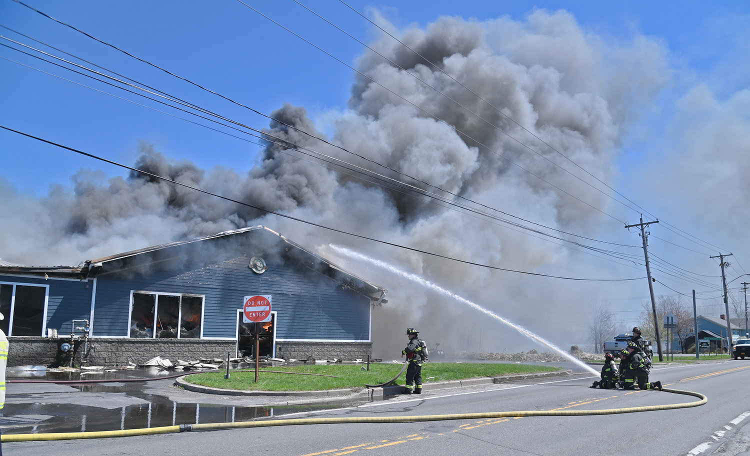 SMOKE RISES — Rome firefighters blast water into the roof of Mazzaferro's Meats & Deli while the popular market burns on Friday. Thick black smoke could be seen for miles around.