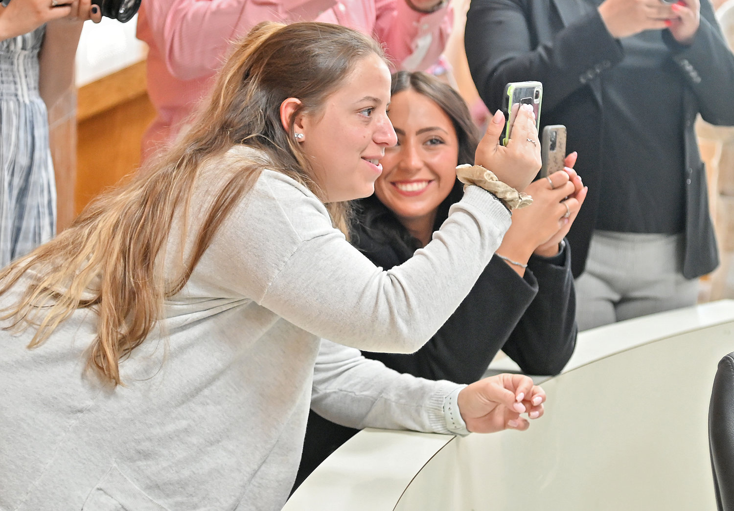 PROUD FAMILY — Gianna Cirasuolo and Gianna Calabrese, sister and girlfriend, respectively, of new recruit Michael Cirasuolo, get pictures of him signing the department's new member book at his swearing-in ceremony on Friday.