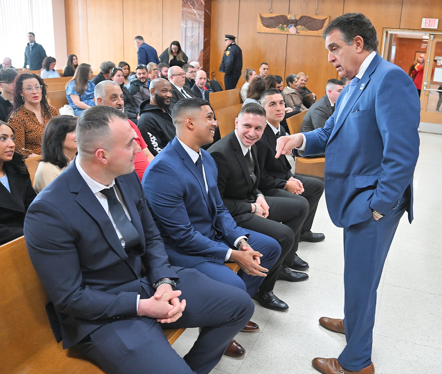 MEETING THE BOSS — Utica Mayor Robert Palmieri, right, greets and jokes with several of the new police officer recruits before their swearing-in ceremony Friday morning.