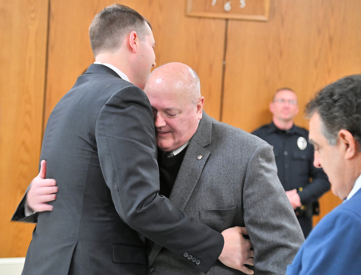 FATHER AND SON — Longtime Utica Police Chief Mark Williams hugs his son, Stephen Williams, during the son's swearing in ceremony at Utica City Hall on Friday. Stephen Williams is now a third generation Utica police officer.