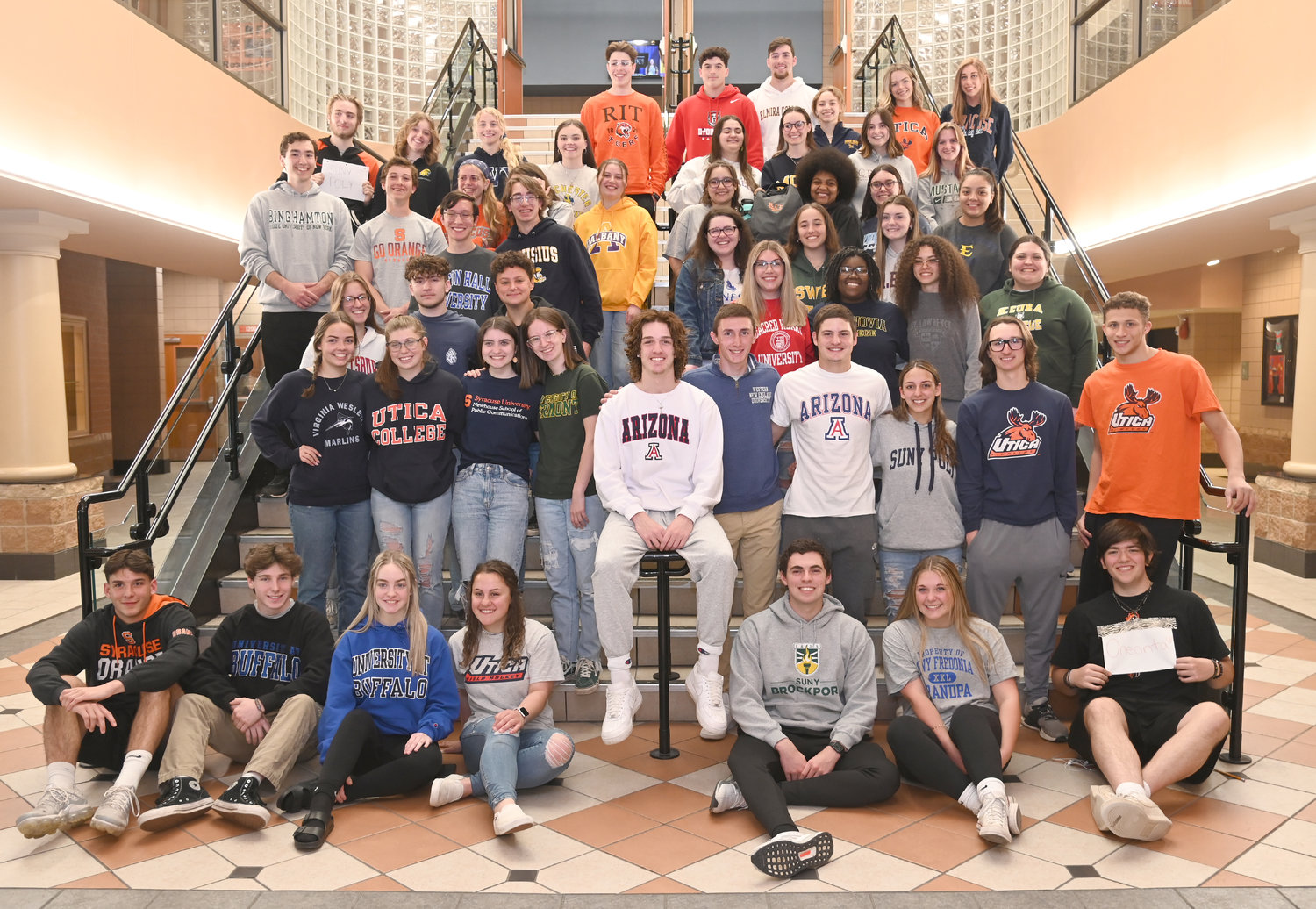 Decked out in the gear of their future colleges and universities, a group of several dozen seniors at Rome Free Academy pose for a group photo at the school on Monday. May 2, was National Decision Day, the deadline day for seniors to pick their institutions and enroll for the fall.