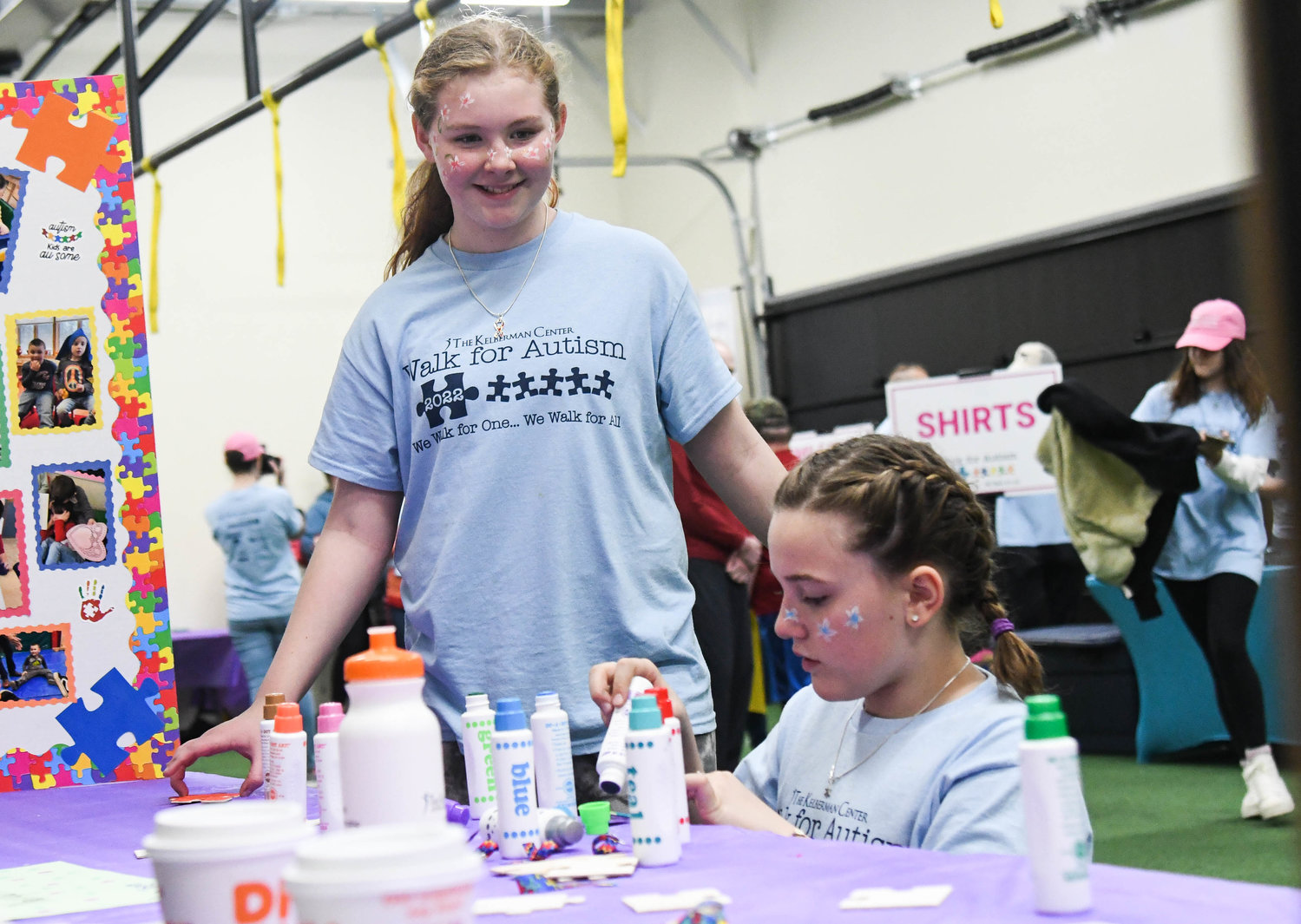 Shea Mundell, left, and Reese Rowlands decorate colored puzzle pieces during the annual Walk for Autism on Saturday at The Fitness Mill in Utica. The event, which seeks to raise awareness of Autism Spectrum Disorder and funding for autism programs and services at the Kelberman Center, drew scores of participants.