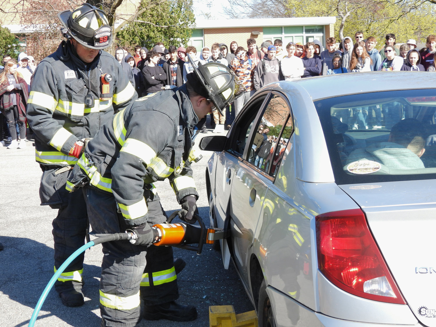 Members of the Oneida Fire Department demonstrate what lengths sometimes need to be taken to get people out of a car crash at the Oneida High School Mock DWI assembly on Thursday.