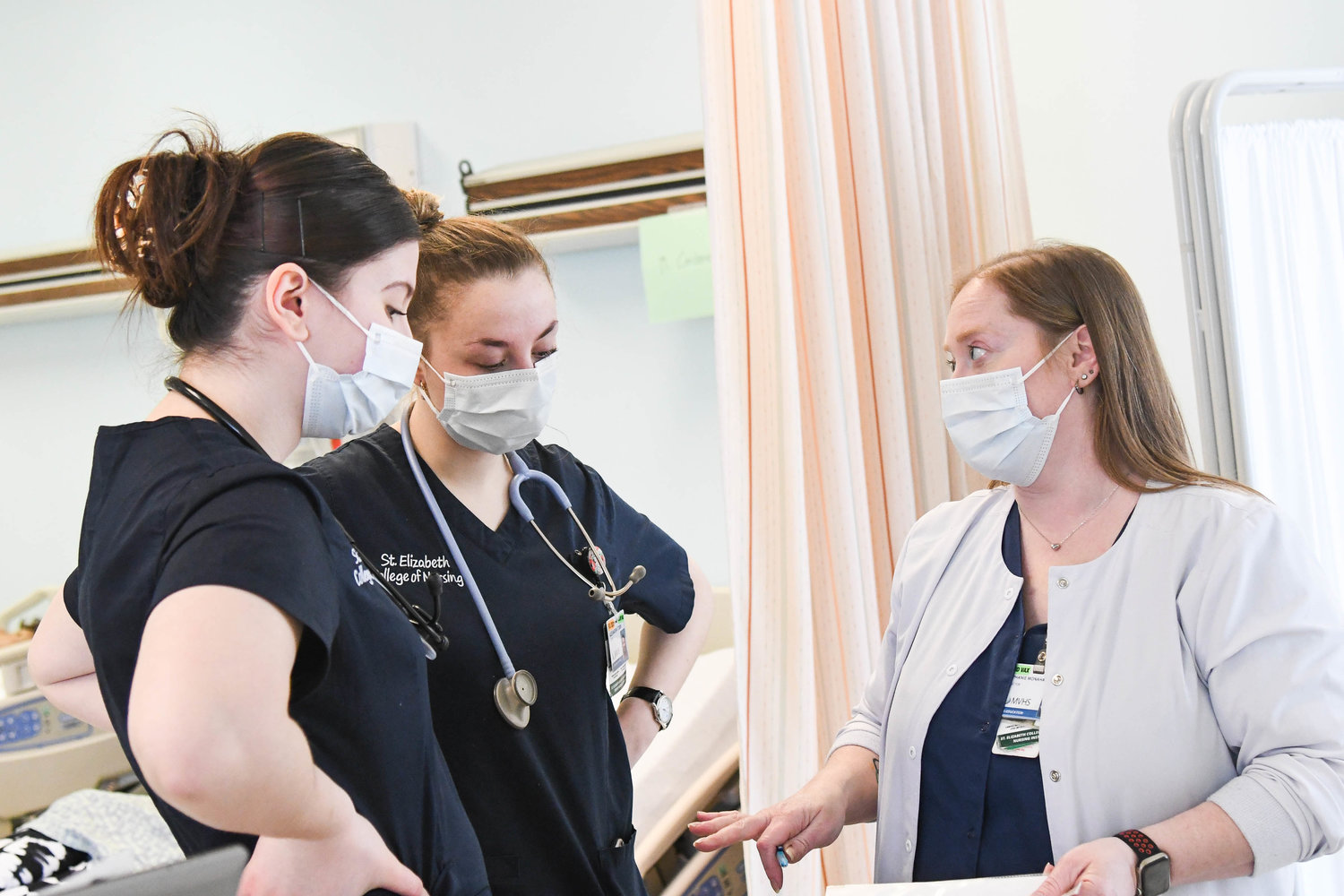 From left, Adelisa Muskic and Alexandria Tobin talk with instructor Stephanie Monahan at St. Elizabeth College of Nursing during class on Friday, April 22.