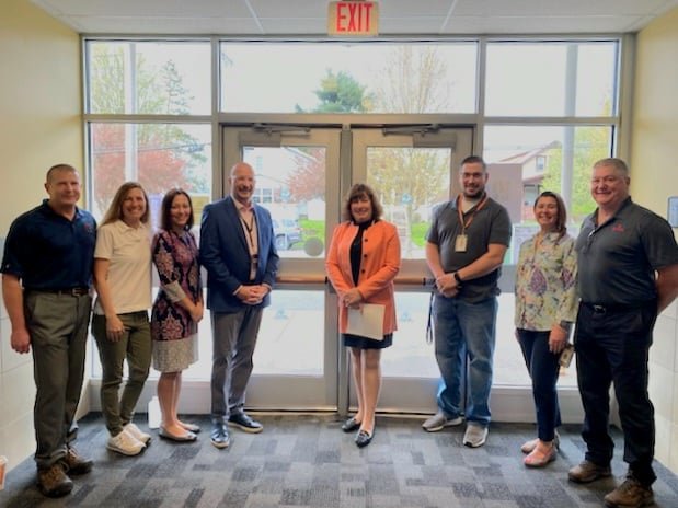 Representatives from Revere Copper Products, the Rome City School District and Assemblywomen Marianne Buttenschon unveil antimicrobial copper tape strips that has been installed on doors at the building to fight the spread of germs.