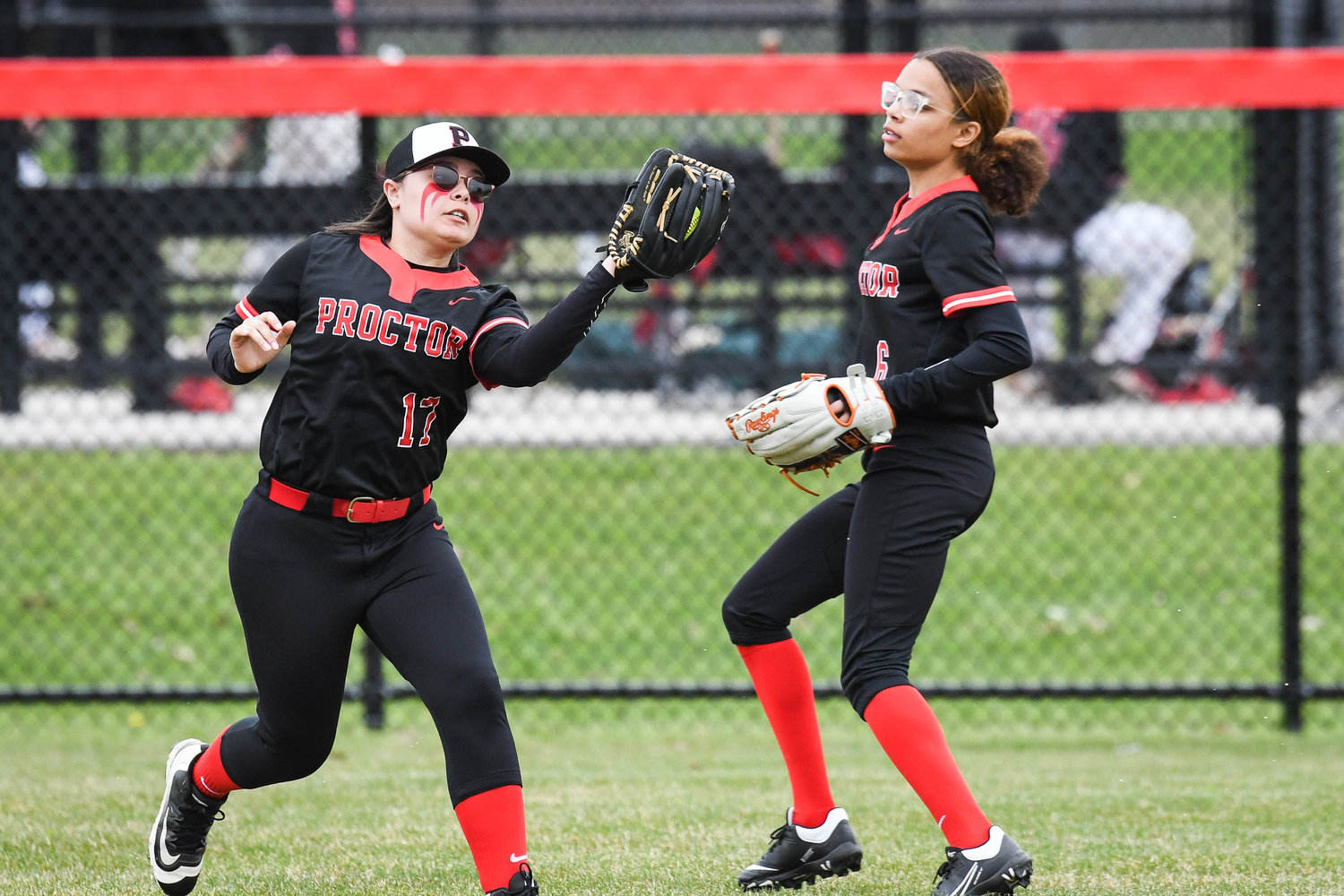 Utica Proctor outfielder Brianna Schneider, left, makes a catch during the game against Vernon-Verona-Sherrill on Friday in Utica. The Raiders lost 4-3. At right is outfielder Elicia Barefoot.