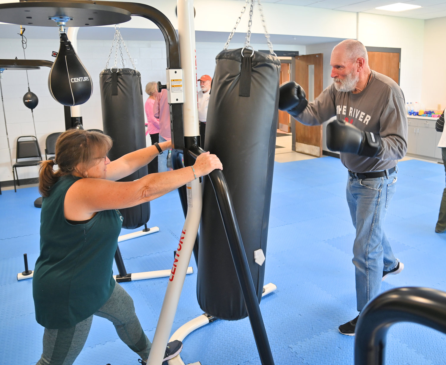 Tom Cartrucko punches away at the bag at 50 Forward Mohawk Valley with Denise Spagnola holding it down for him.
