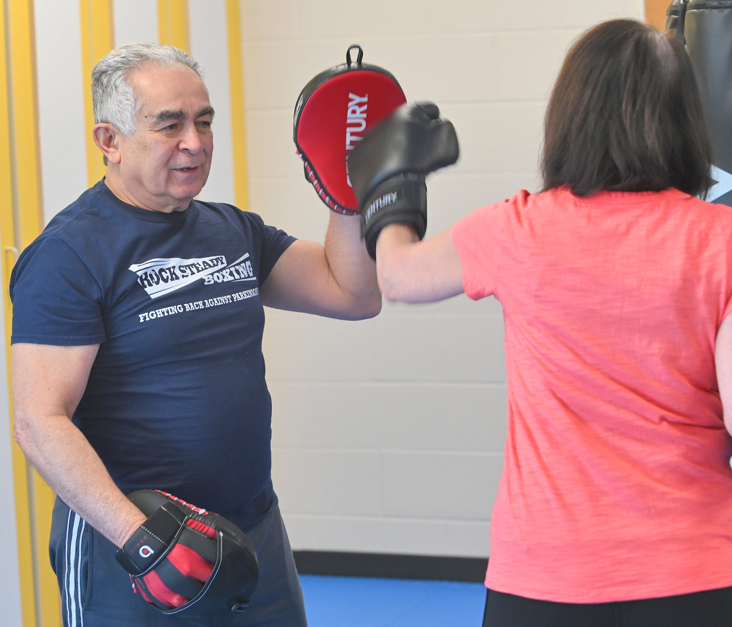 Rock Steady Boxing program coach Angel Heredia works with participant Jeanne Stone during a class at 50 Forward Mohawk Valley.