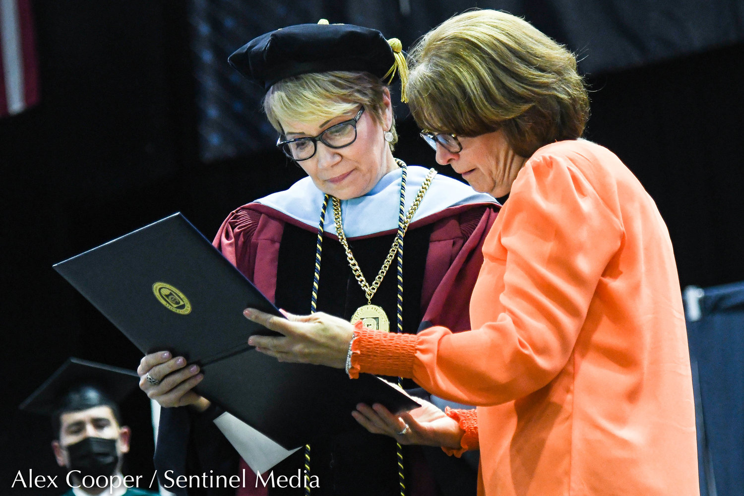 Utica University president Dr. Laura Casamento presents John Paul Ramel's degree to a family member during the school's undergraduate commencement ceremony on Thursday at the Adirondack Bank Center at the Utica Memorial Auditorium.