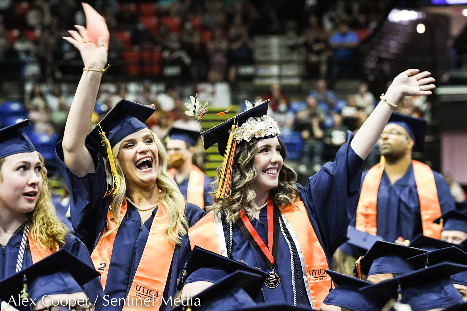 From left, Utica University graduates Verona Deliu and Amra Becirevic wave to family and loved ones in the crowd during the school's undergraduate commencement ceremony on Thursday, May 12 at the Adirondack Bank Center at the Utica Memorial Auditorium.