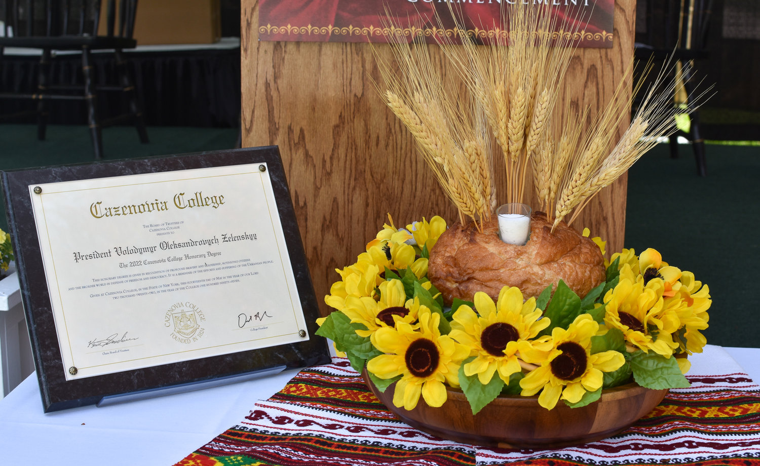 In the spirit of Ukrainian tradition, an arrangement consisting of bread, wheat, and salt along with sunflowers was on display during the graduation ceremony to symbolize Cazenovia College's support of democracy and peace.