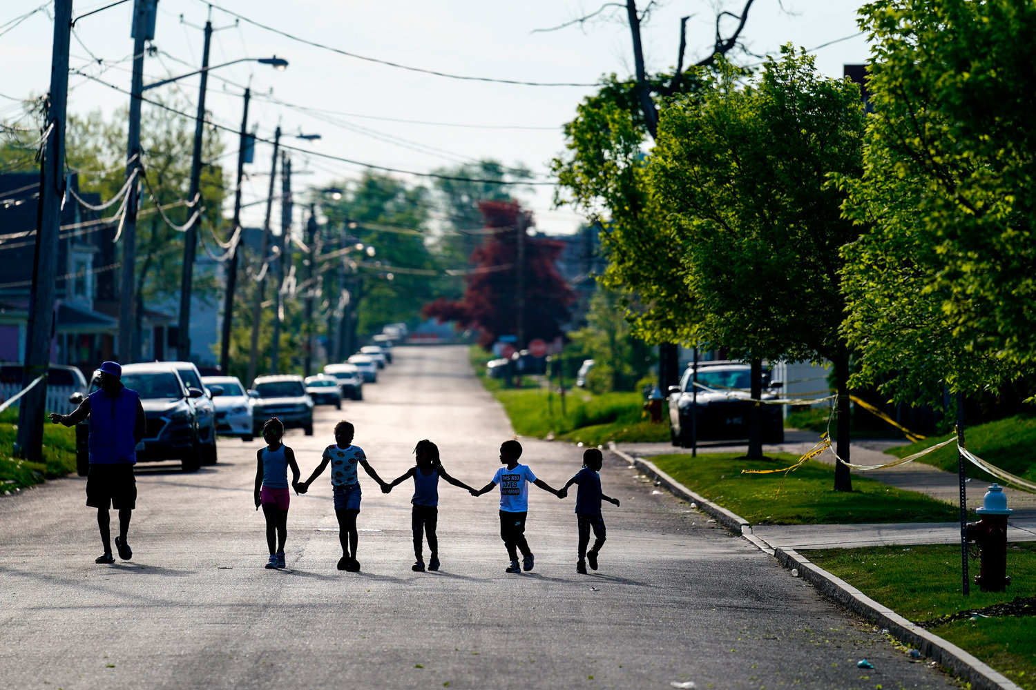 Children walk hand in hand out near the scene of a shooting at a supermarket in Buffalo, N.Y., Sunday, May 15, 2022. (AP Photo/Matt Rourke)
