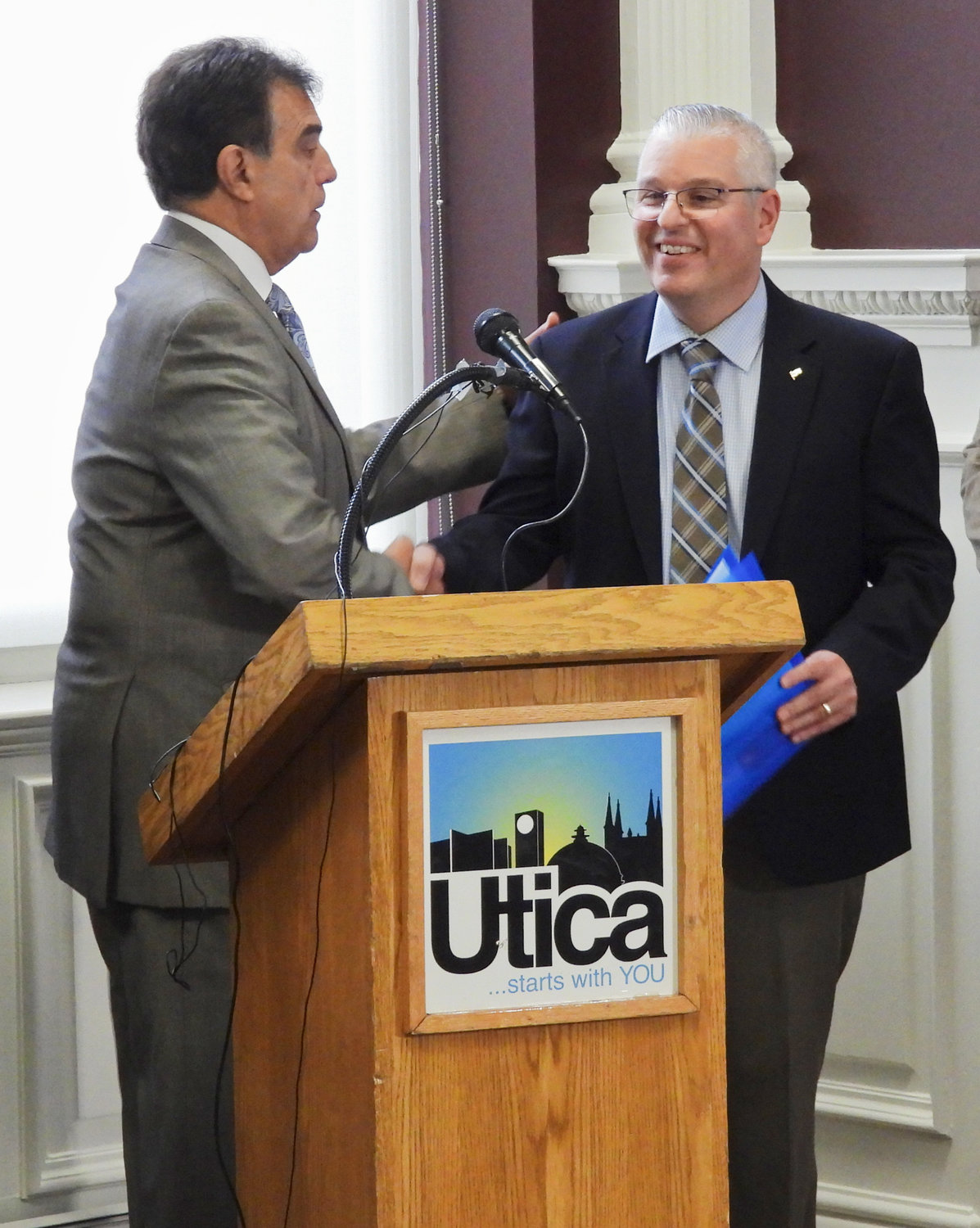Utica Mayor Robert Palmieri shakes hands with Barton & Loguidice President and CEO John Brusa, thanking B & L for its commitment and investment in Utica. B & L will be moving into the former Commercial Travelers building at 70 Genesee Street in in Utica.