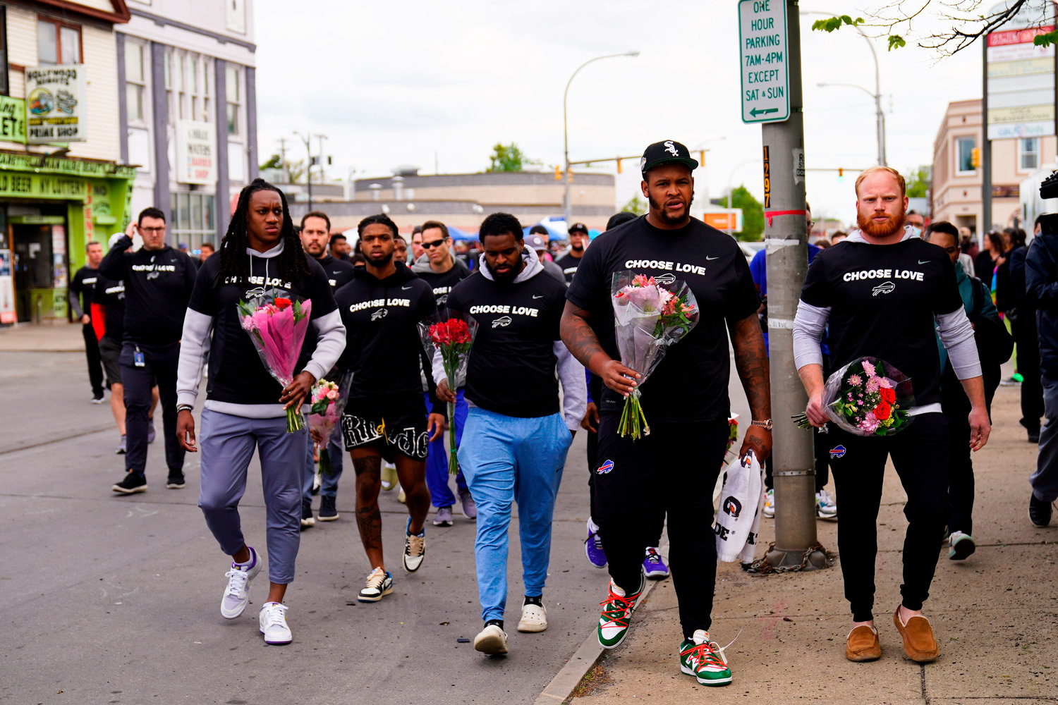 Members of the Buffalo Bills make their way to the scene of Saturday's shooting at a supermarket, in Buffalo, N.Y., Wednesday, May 18, 2022. (AP Photo/Matt Rourke)