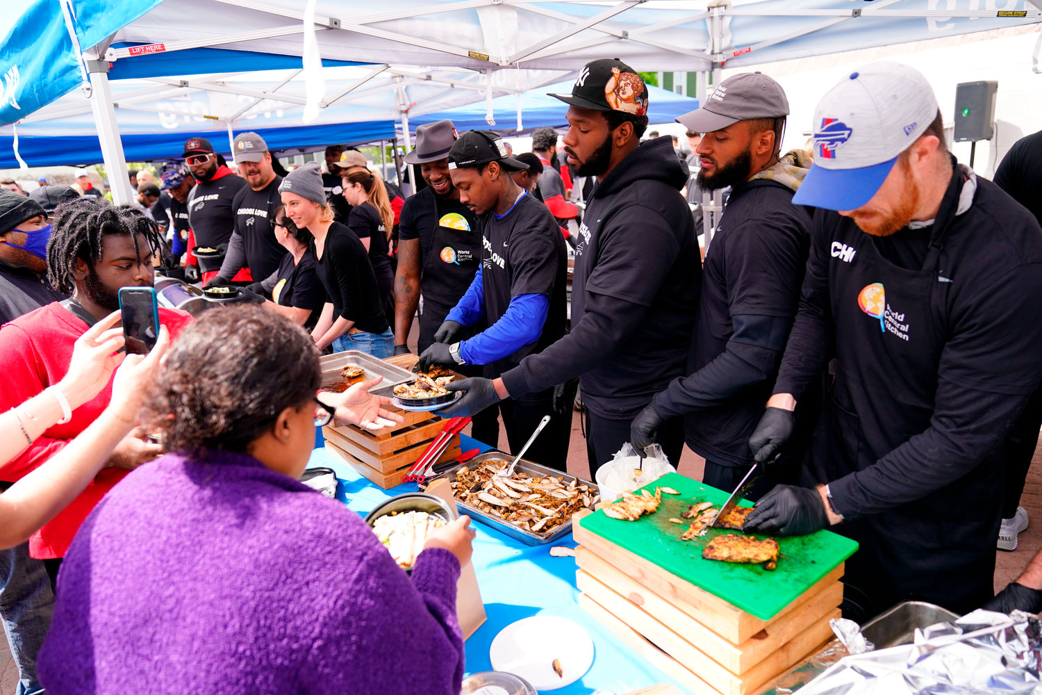 Buffalo Bills players serve food at a World Central Kitchen tent near the scene of Saturday's shooting at a supermarket, in Buffalo, N.Y., Wednesday, May 18, 2022. (AP Photo/Matt Rourke)