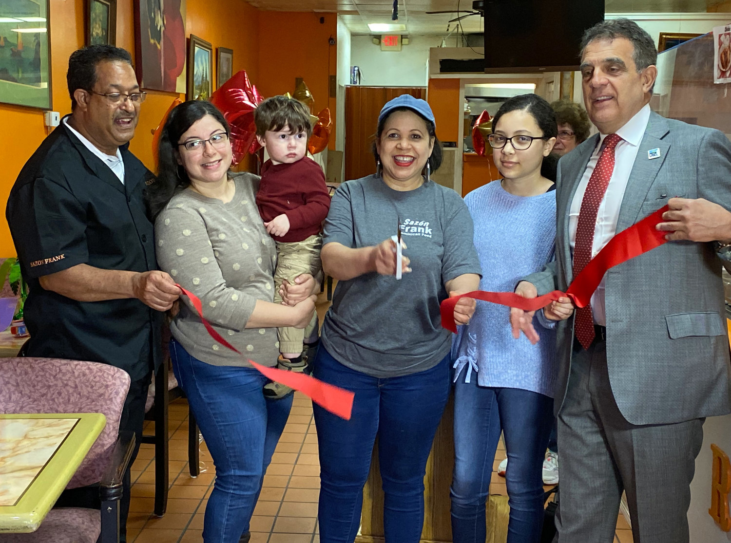 Nieve Nunez (center) joined by her family and Utica Mayor Robert Palmieri (right).