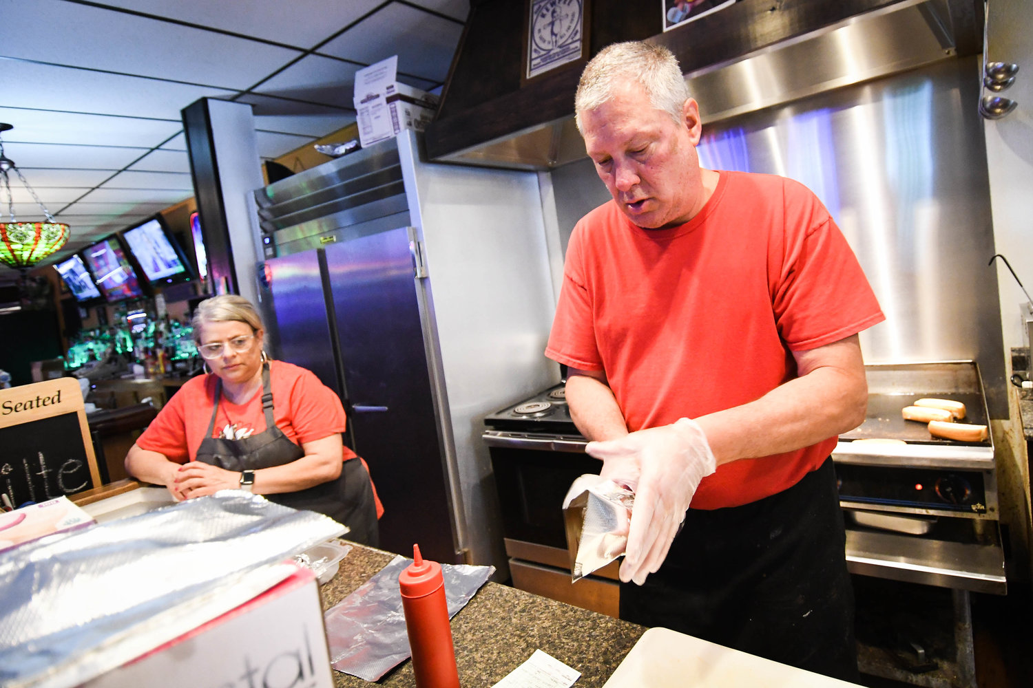 Michael Griffin works on to-go orders in the kitchen at his bar, Griffin's Pub, in Utica. “If you come into this place, hopefully, you leave with a great experience. Most people will go out of their way to talk to you,” he said. “It’s a very friendly place.”