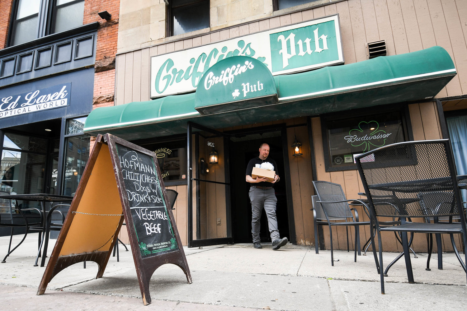 A customer leaves with a to-go order outside of Griffin's Pub in Utica.