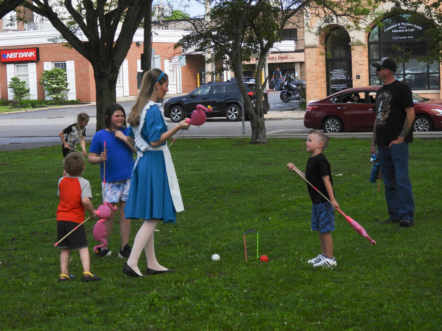 Local children play flamingo croquet with Alice, recreating a scene from "Alice in Wonderland" as part of the Oneida Parks and Recreation Department's "Through the Looking Glass" event, with members of the Bogardus Performing Art Center take the role of beloved characters.