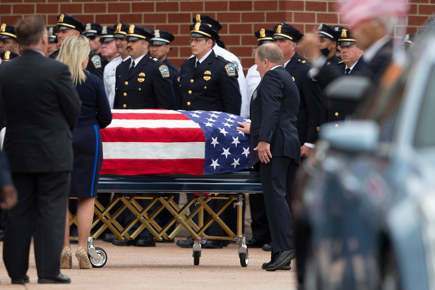 A person touches the casket of Aaron Salter Jr. during a funeral service at The Chapel at Crosspoint on Wednesday, May 25, 2022, in Getzville, N.Y. Salter Jr. was killed in the Buffalo supermarket shooting on May 14. (AP Photo/Joshua Bessex)