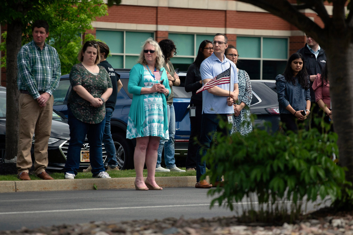 People stand to watch the procession after the funeral service for Aaron Salter Jr. at The Chapel at Crosspoint on Wednesday, May 25, 2022, in Getzville, N.Y. Salter Jr. was killed in the Buffalo supermarket shooting on May 14. (AP Photo/Joshua Bessex)