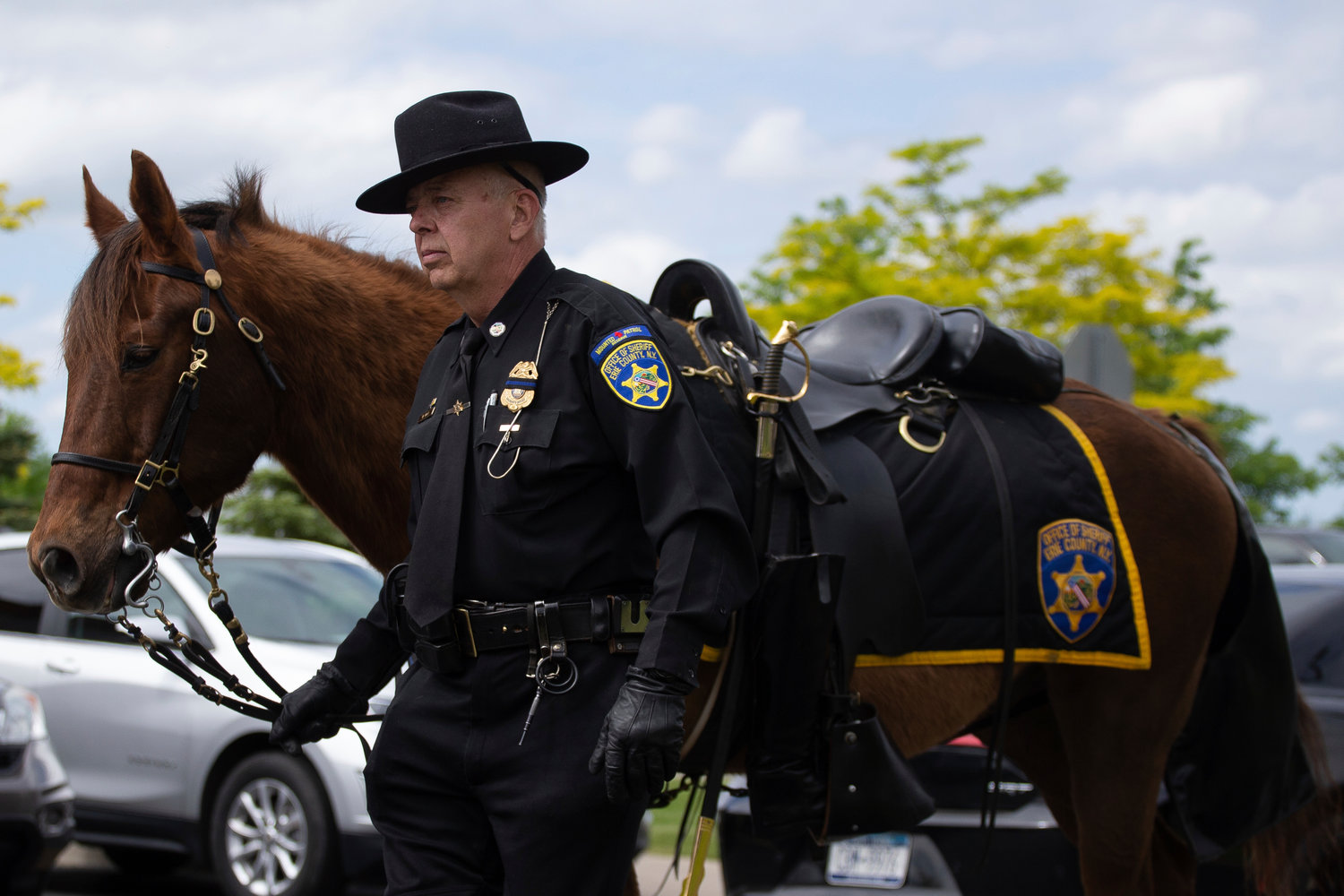 Capt. Wayne Wolfe, with the Erie County Sheriff's Mounted Reserve Unit, leads a riderless horse before the funeral service for Aaron Salter Jr. at The Chapel at Crosspoint on Wednesday, May 25, 2022, in Getzville, N.Y. Salter Jr. was killed in the Buffalo supermarket shooting on May 14. (AP Photo/Joshua Bessex)