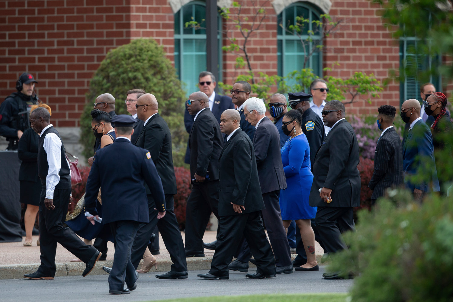 The family of Aaron Salter Jr. walks by police officers before a funeral service for Salter Jr. at The Chapel at Crosspoint on Wednesday, May 25, 2022, in Getzville, N.Y. Salter Jr. was killed in the Buffalo supermarket shooting on May 14. (AP Photo/Joshua Bessex)