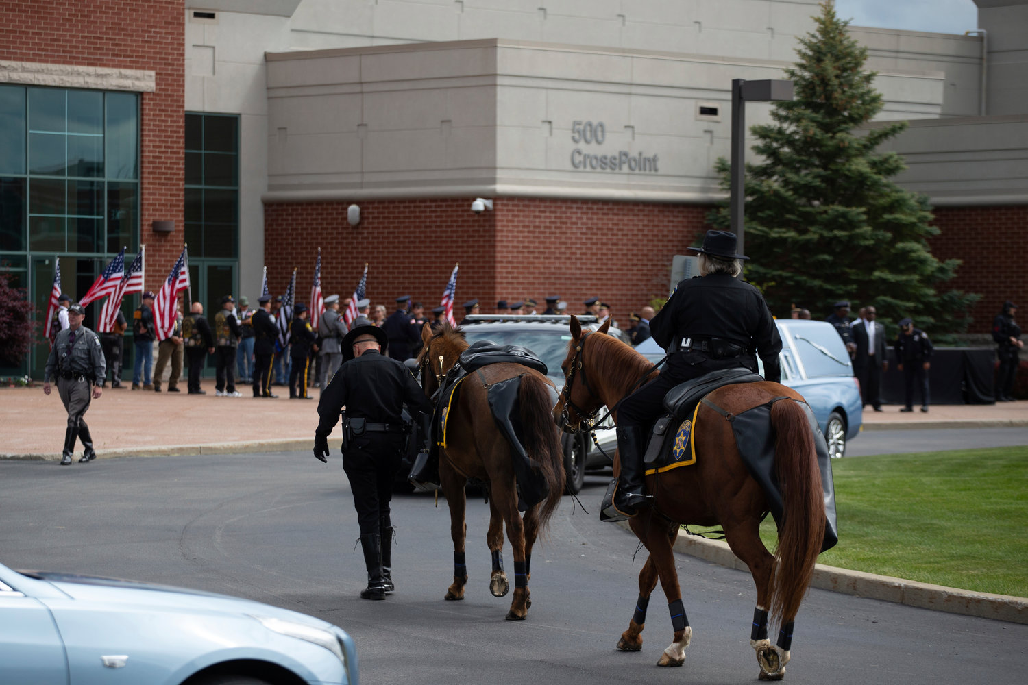 Capt. Wayne Wolfe, center, and Lt. Ruby Davis-Joseph, right, with the Erie County Sheriff's Mounted Reserve Unit, leads a riderless horse before the funeral service for Aaron Salter Jr. at The Chapel at Crosspoint on Wednesday, May 25, 2022, in Getzville, N.Y.. Salter Jr. was killed in the Buffalo supermarket shooting on May 14. (AP Photo/Joshua Bessex)