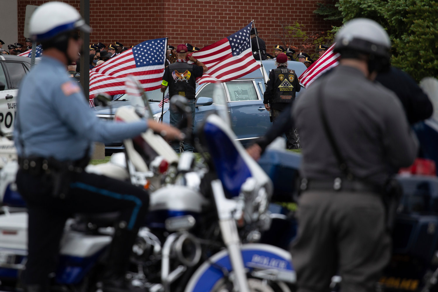 People salute during the funeral service for Aaron Salter Jr. at The Chapel on Crosspoint on Wednesday, May 25, 2022, in Getzville, N.Y. Salter Jr. was killed in the Buffalo supermarket shooting on May 14. (AP Photo/Joshua Bessex)