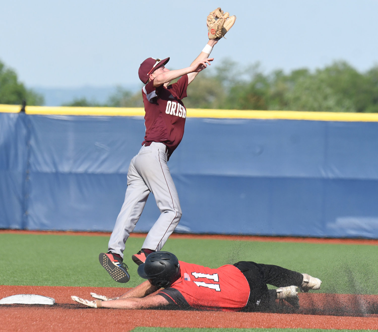 Oriskany senior second baseman Alex Burrows leaps to make a catch as Morrisville-Eaton baserunner Nicholas Brady dives in safety on a stolen base attempt in the fourth inning of Tuesday’s Section III Class D baseball title game at Onondaga Community College. Brady scored in the inning and later drove in the eventual game-winning run, while also throwing a complete game in the Warriors’ 3-2 win.