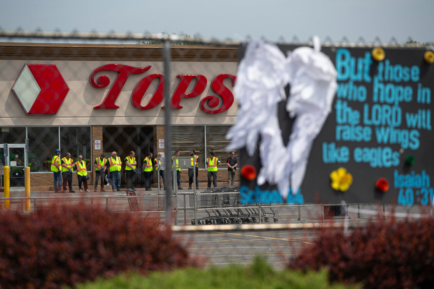 FILE - Investigators stand outside during a moment of silence for the victims of the Buffalo supermarket shooting outside the Tops Friendly Market on Saturday, May 21, 2022, in Buffalo, N.Y. Long before an 18-year-old avowed white supremacist inflicted terror at a Buffalo supermarket, the city's Black neighborhoods, like many others around the nation, had been dealing with wounds that are generations old. (AP Photo/Joshua Bessex, File)