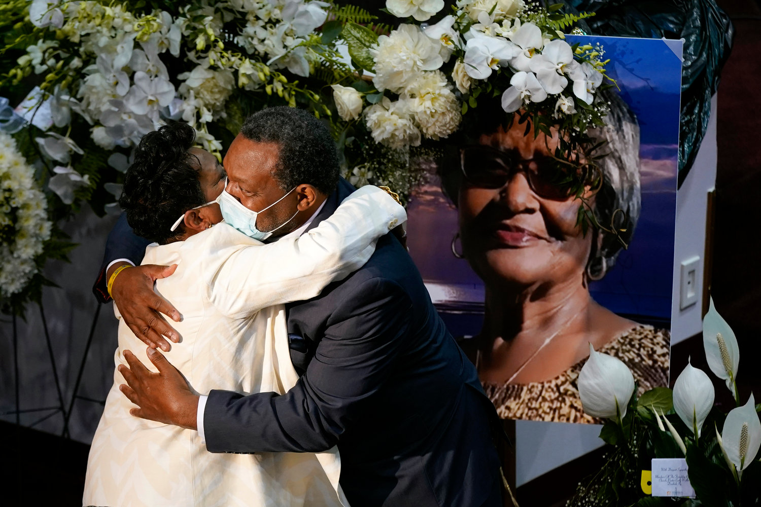 A mourner embraces Angela Crawley, left, daughter of Ruth Whitfield, a victim of the Buffalo supermarket shooting, before a memorial service at Mt. Olive Baptist Church with Vice President Kamala Harris in attendance, Saturday, May 28, 2022, in Buffalo, N.Y. (AP Photo/Patrick Semansky)