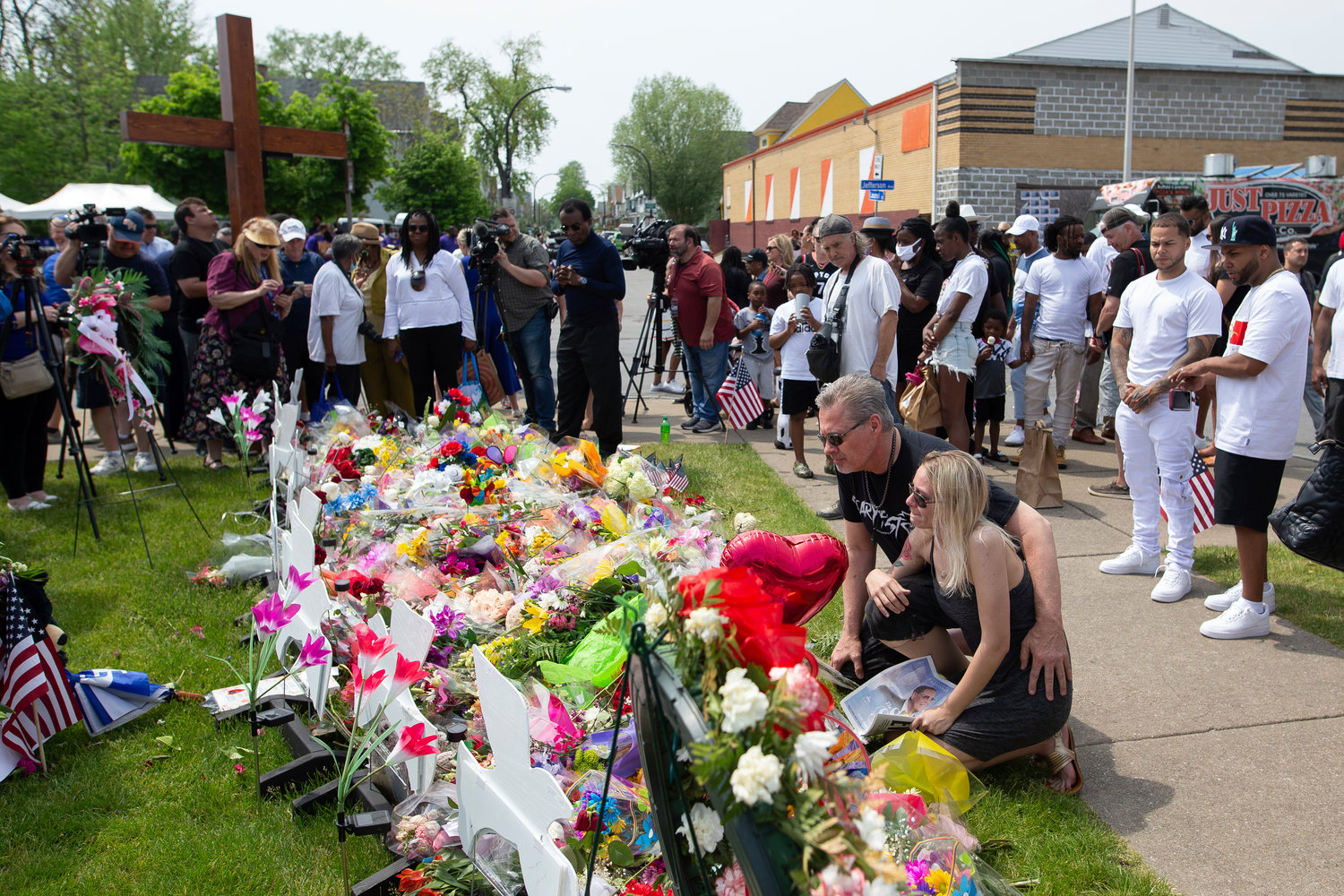 Michael Jordan and Heather Delorm, friends of Buffalo shooting victim Roberta Drury, visit a memorial for the victims of the Buffalo supermarket shooting outside the Tops Friendly Market on Saturday, May 21, 2022, in Buffalo, N.Y.  Tops was encouraging people to join its stores in a moment of silence to honor the shooting victims Saturday at 2:30 p.m., the approximate time of the attack a week earlier. Buffalo Mayor Byron Brown also called for 123 seconds of silence from 2:28 p.m. to 2:31 p.m., followed by the ringing of church bells 13 times throughout the city to honor the 10 people killed and three wounded.(AP Photo/Joshua Bessex)