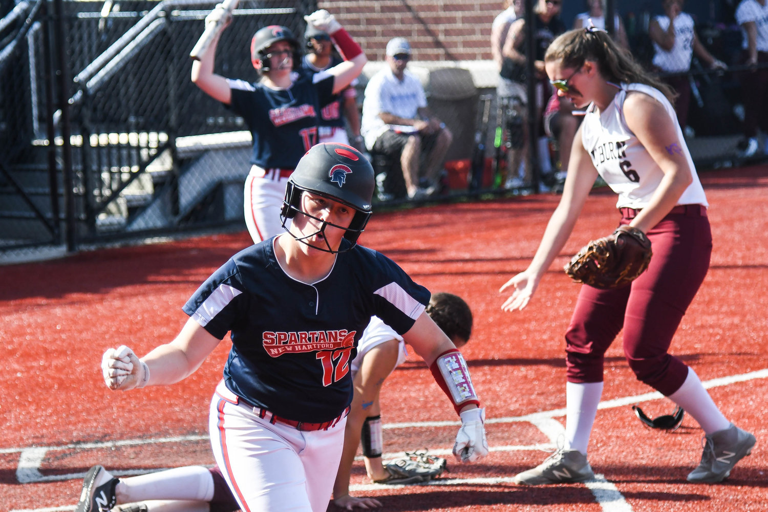 New Hartford baserunner Sienna Holmes celebrates after sliding in safe at home plate during the Section III Class A final against Auburn on Thursday at Onondaga Community College in Syracuse. Holmes pitched the Spartans to a 6-3 win.