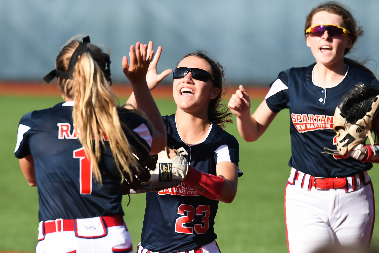 New Hartford player Olivia Vitullo (23) celebrates with teammate Taylor Raux (1) after making a play in the outfield during the Section III Class A final against Auburn on Thursday at Onondaga Community College.