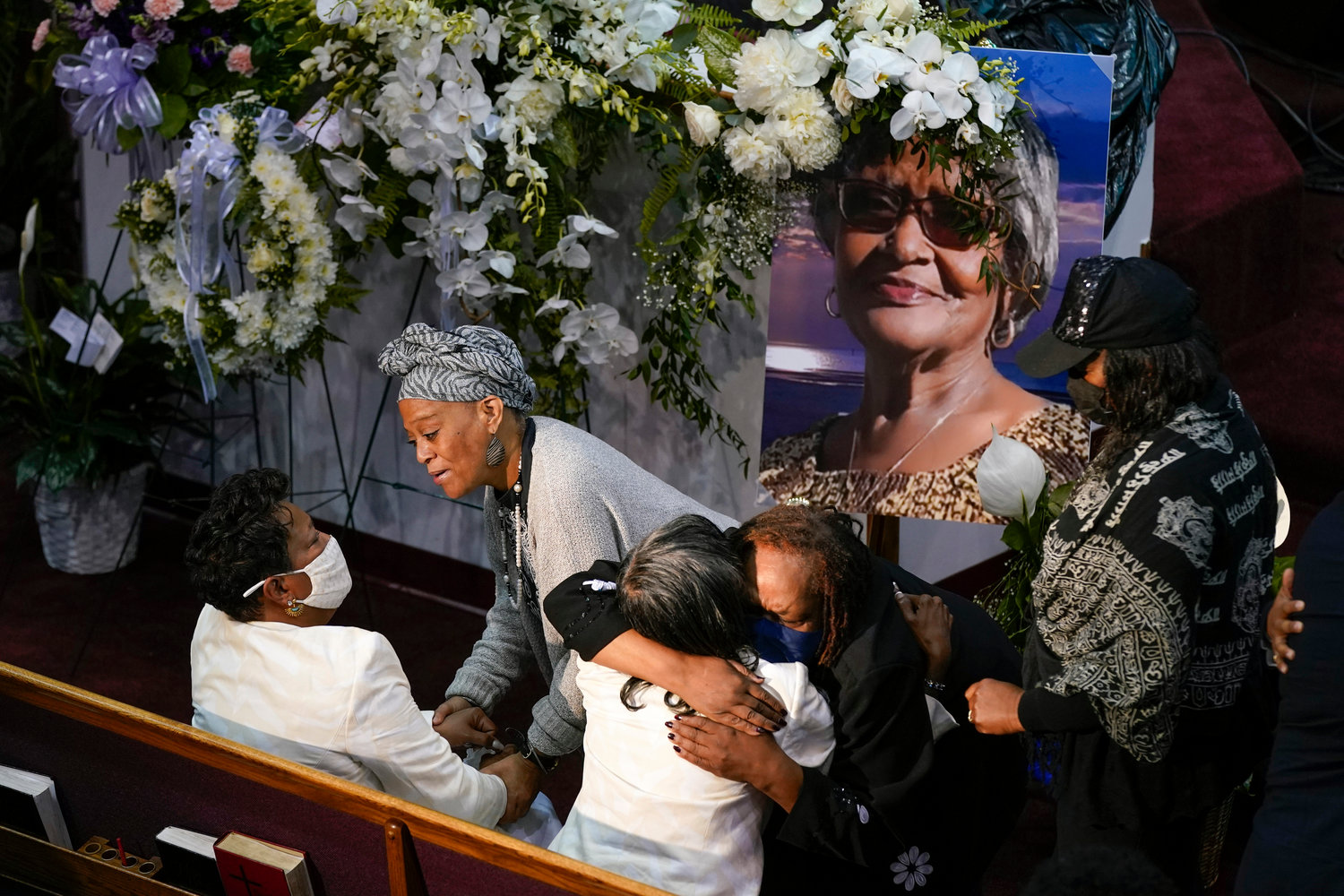 Mourners comfort Angela Crawley, seated at bottom left, and Robin Harris, daughters of Ruth Whitfield, a victim of the Buffalo supermarket shooting, before a memorial service at Mt. Olive Baptist Church with Vice President Kamala Harris in attendance, Saturday, May 28, 2022, in Buffalo, N.Y.