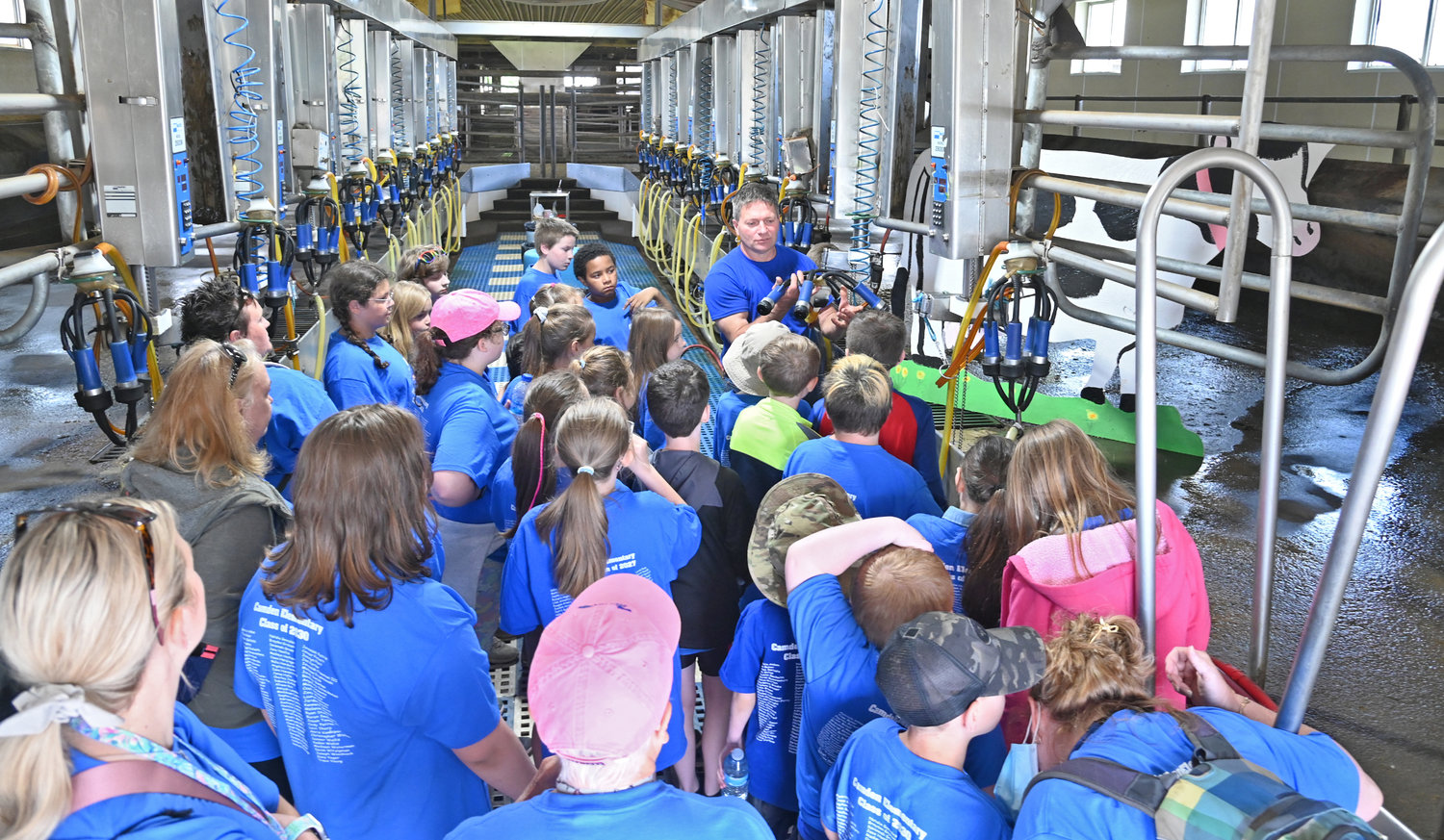 FARM FEST — Pat Van Lieshout explains the milking process to Camden Elementary School students during Farm Fest activities at the DiNitto Farm on Benton Road in Marcy on Friday. Hundreds of youngsters from across the region toured the farm, learning about agriculture, farm life and how food goes from the farm to the plate.