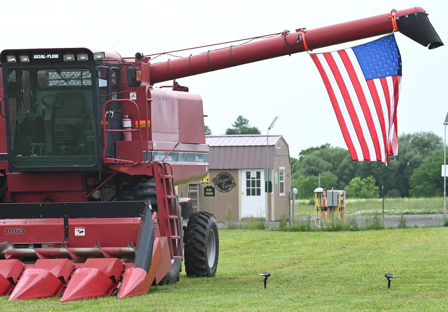 SHOWING PRIDE — An American flag is hung from a combine at Wagner Farms, 5841 Old Oneida Road, Rome, earlier this week.  The spring weather has been favorable for a host of different crops at the local agribusiness, with corn, potatoes and other vegetables thriving, according to Wagner Farm’s Facebook page.