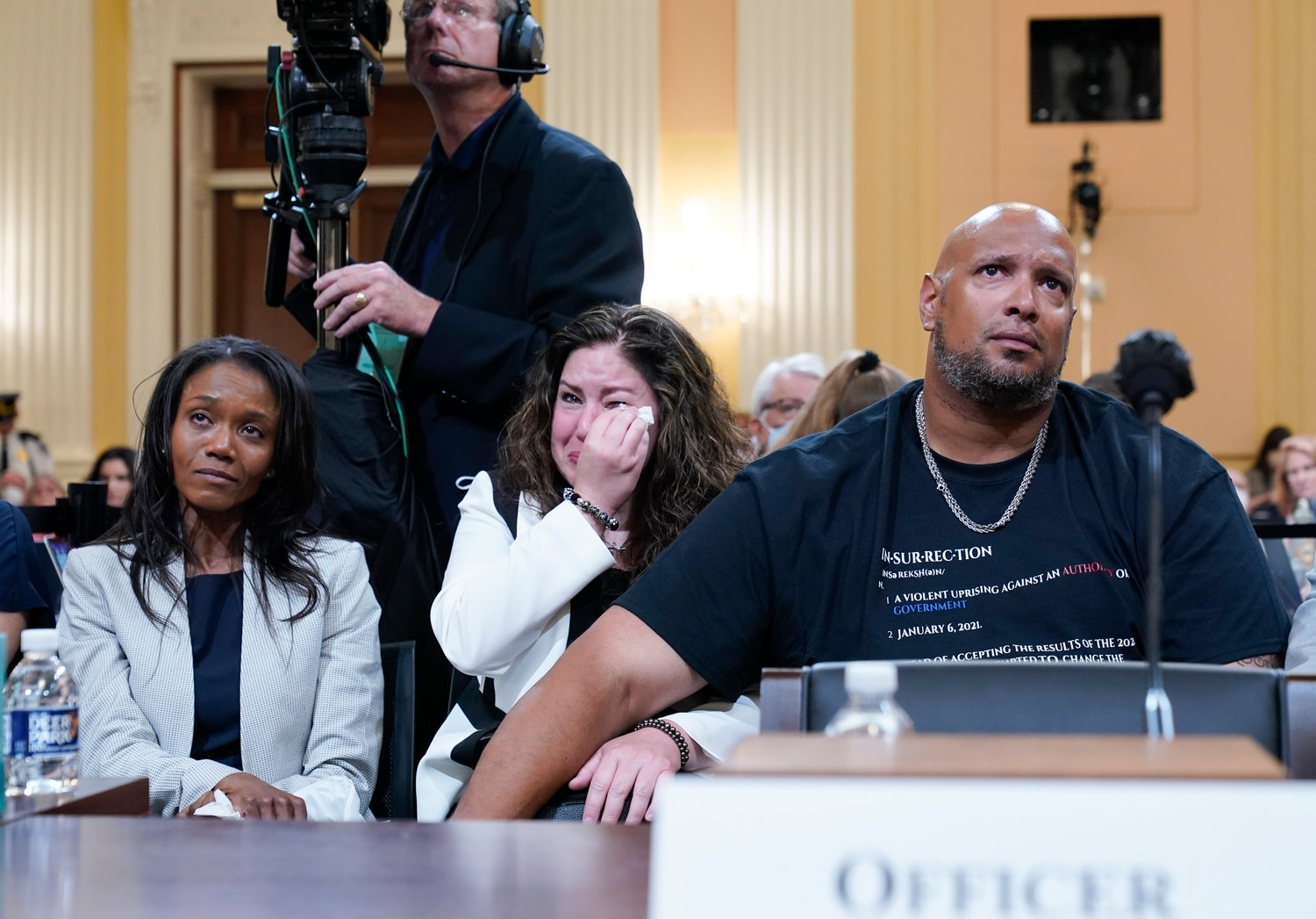 U.S. Capitol Police Sgt. Harry Dunn, right, Sandra Garza, the longtime partner of fallen Capitol Police Officer Brian Sicknick, center, and Serena Liebengood, widow of Capitol Police officer Howie Liebengood, left, react as a video of the Jan. 6 attack on the U.S. Capitol is played during a public hearing of the House select committee investigating the attack is held on Capitol Hill, Thursday, June 9, 2022, in Washington. (AP Photo/Andrew Harnik)