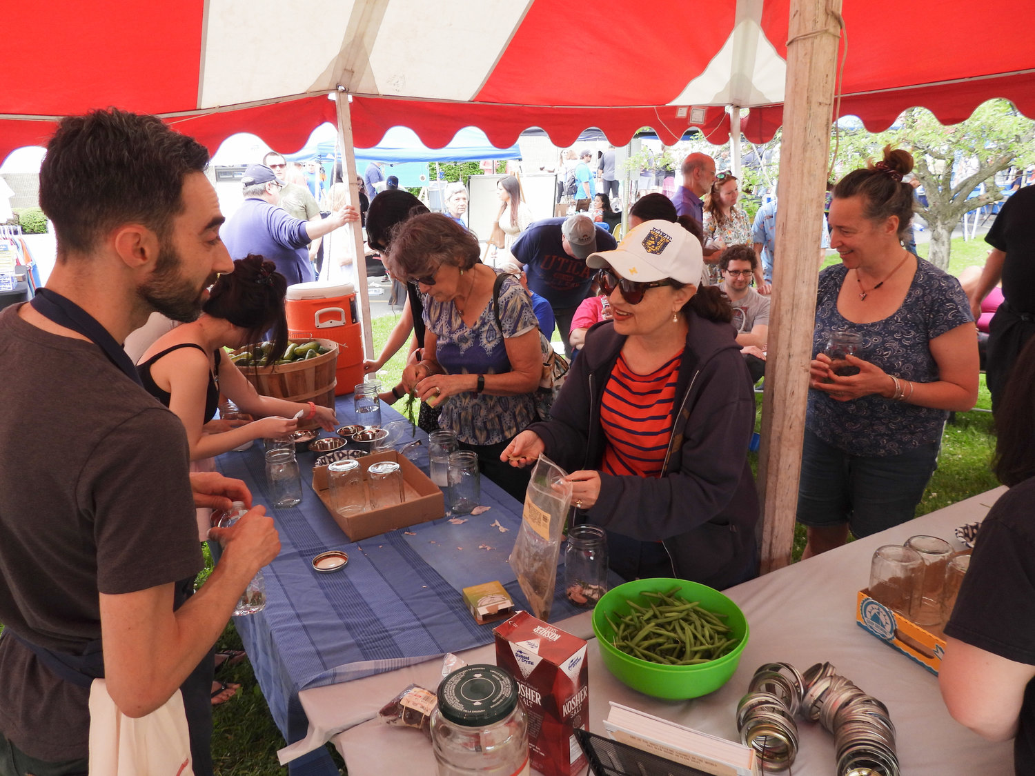 Inauguracyjny festiwal kultury żydowskiej "Jewtica" rozpoczął się w niedzielę 12 czerwca setkami osób w Centrum Społeczności Żydowskiej w Utica.  Ludzie zjeżdżali się z całego świata, aby dzielić się kulturą, skosztować pysznych potraw i nauczyć się czegoś nowego.  Jeffrey Yoskowitz, po lewej, rozmawia z uczestnikami o żydowskiej kuchni i przepisach.  Yoskowitz dał demonstrację, a uczestnicy obserwowali, jak demonstrował przepisy na ogórki kiszone.