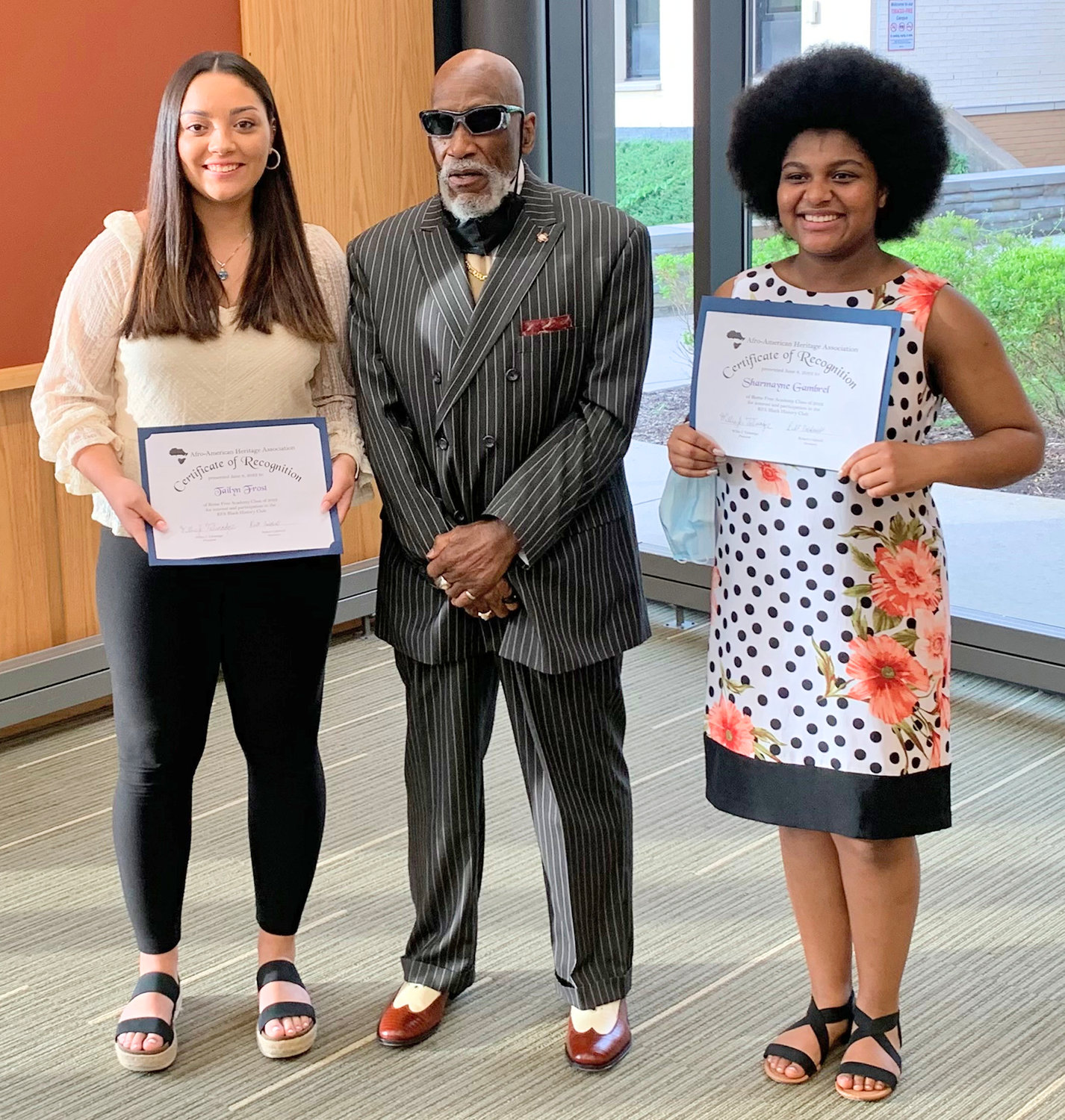 Afro-American Heritage Association President Willie Talmadge presented Tailyn Frost, left, and Sharmayne Gambriel, right, with scholarships during the Rome Branch NAACP annual High School Senior Recognition Night ceremony. (Photos submitted)