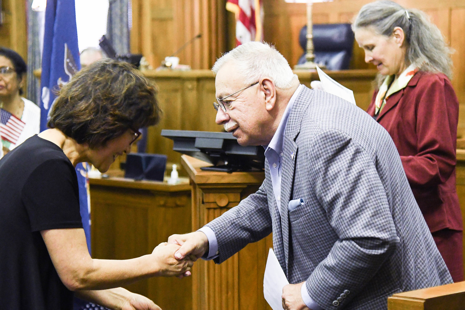 Guest speaker Joe Kelly shakes hands with newly recognized citizens during a naturalization ceremony on Thursday at the federal courthouse in Utica.