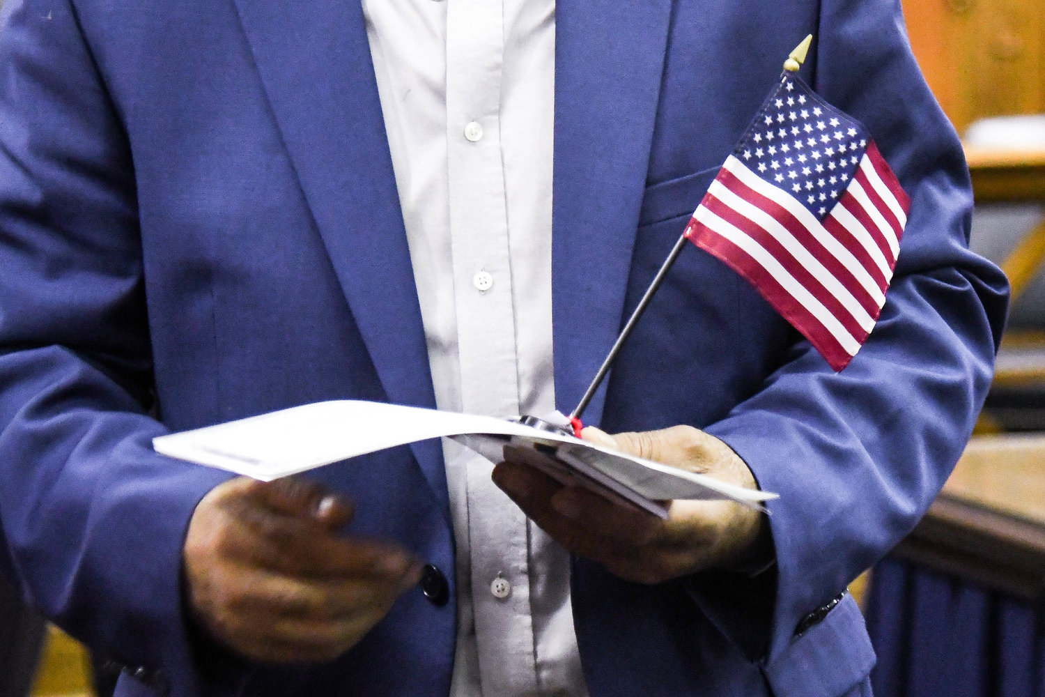 A man holds a small American flag while receiving his certificate of citizenship during a naturalization ceremony on Thursday at the federal courthouse in Utica.