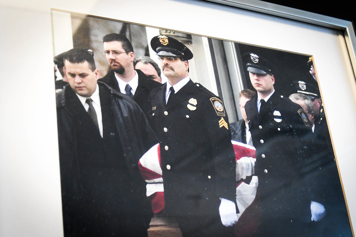 A framed photo of Police Chief Michael Inserra and others carrying the casket of Officer Joseph Corr in 2006. Corr was killed in the line of duty during a vehicle pursuit following a jewelry store robbery. Inserra was heavily involved in the ensuing investigation.