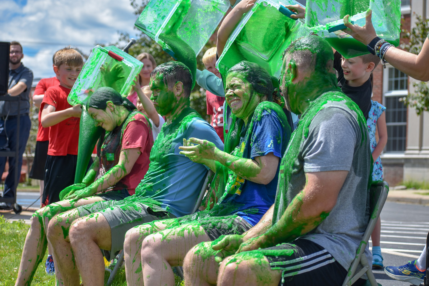 Madison Central School officials face the final pour of slippery green slime as part of a celebration for students in grades K-5 who together surpassed their fundraising goal for the American Heart Association.