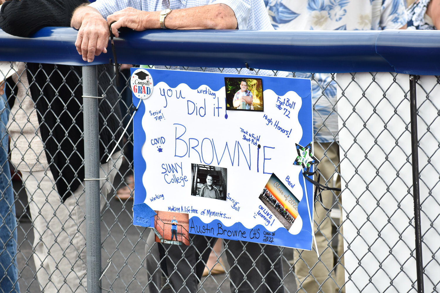 Spectators who couldn't fit on the bleachers leaned against the outer fence. One family hung up a sign to recognize their Camden graduate.