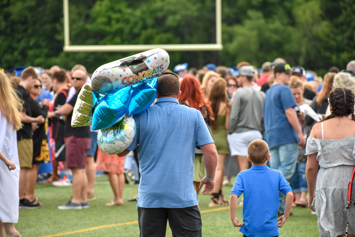 Family search for their special graduate with congratulatory balloons in tow after the Camden high school Class of 2022 commencement ceremony.