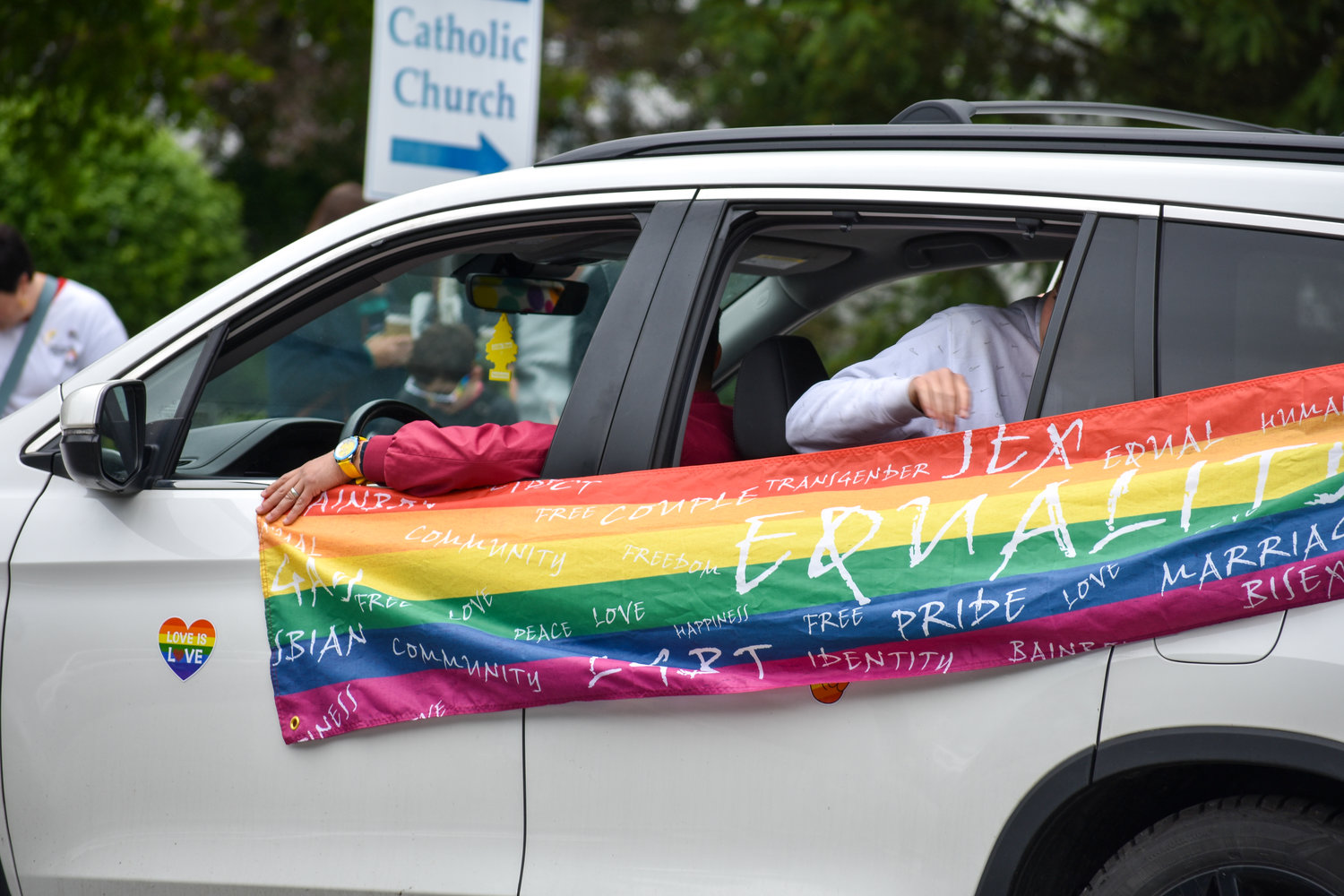 A rainbow flag calling for equality adorns this SUV taking part in Cazenovia's pride parade on Saturday.