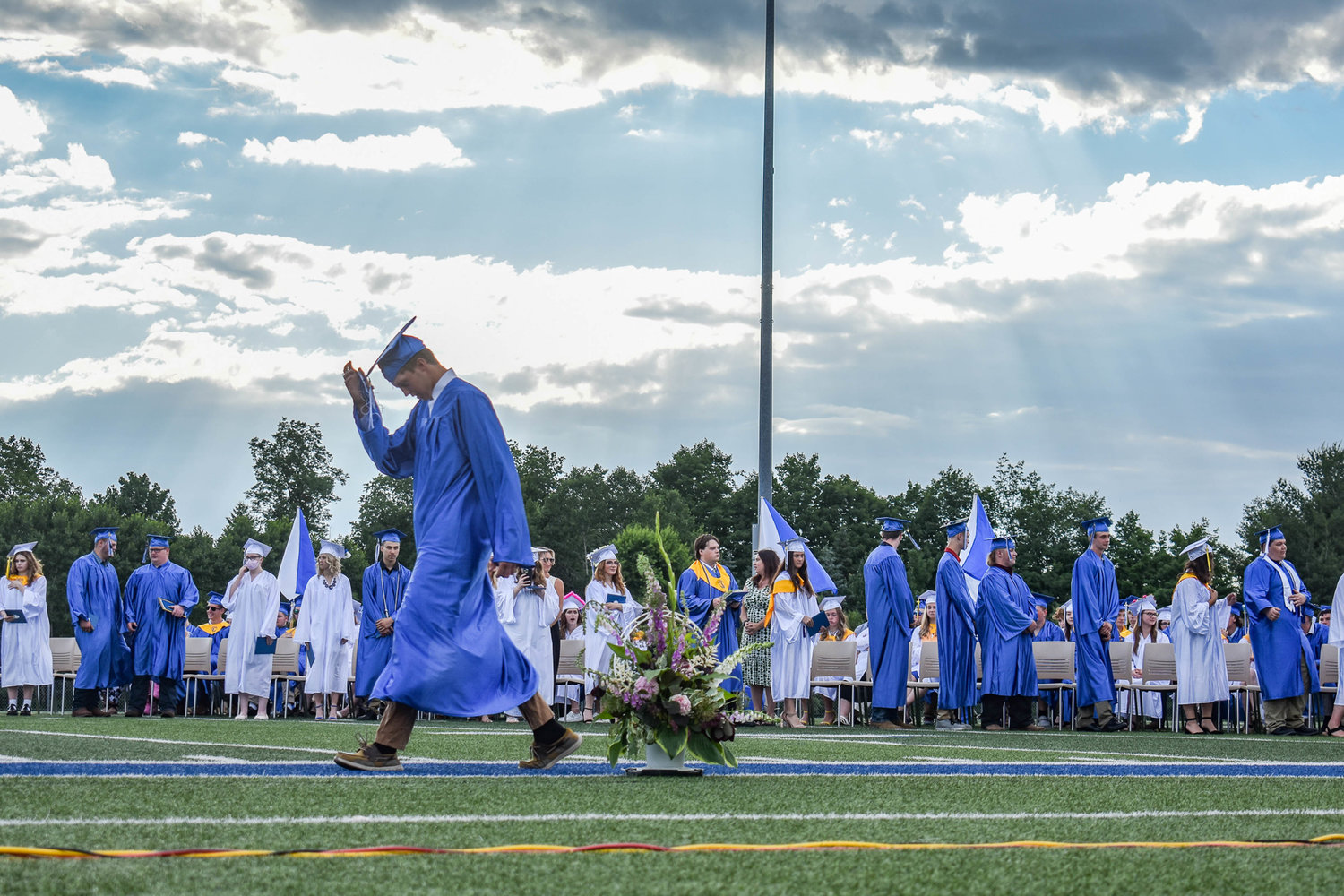 A soon-to-be graduate from Camden High School walks across the field to accept his diploma.